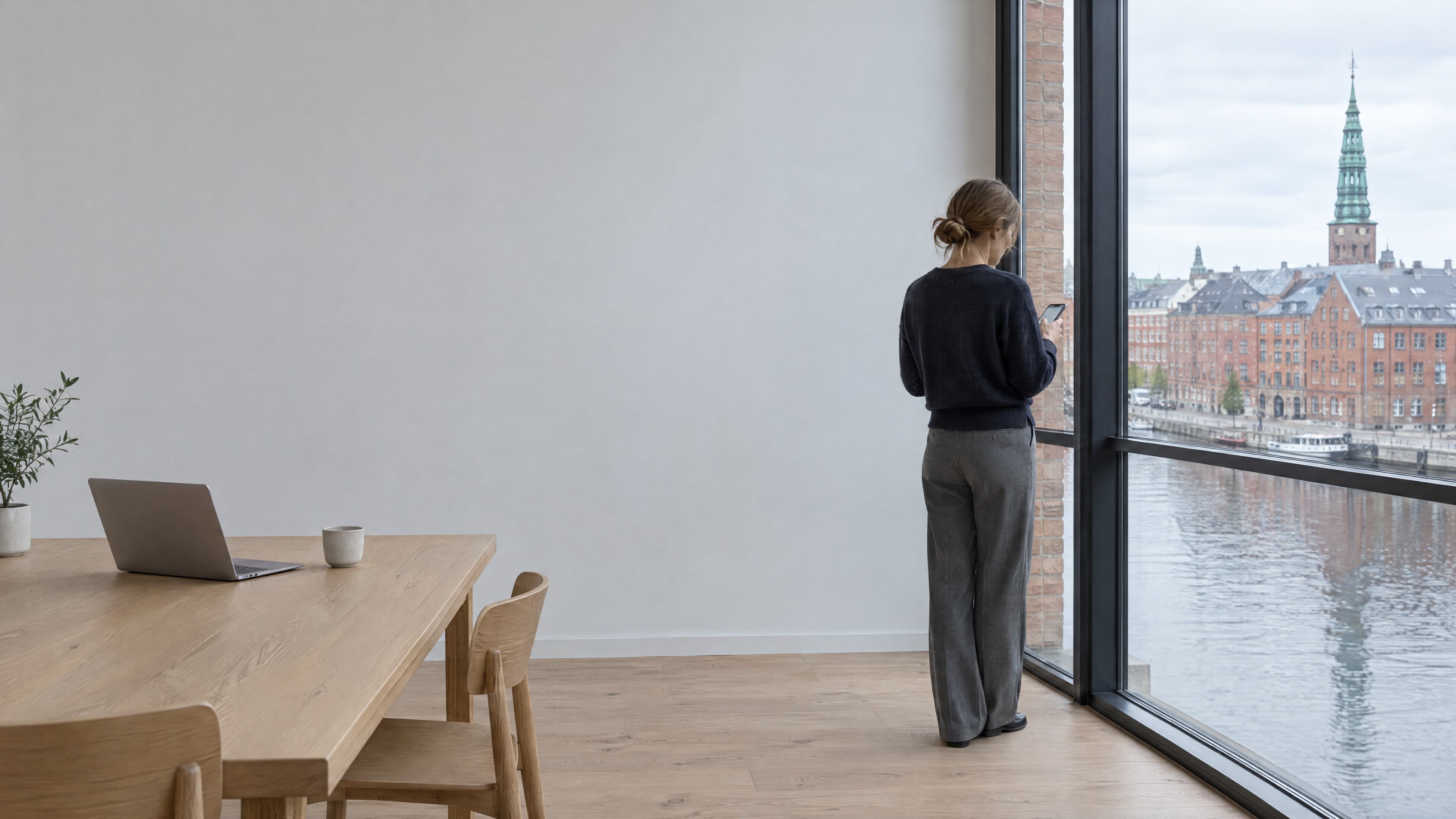 A buyer by the window, reading on her phone.